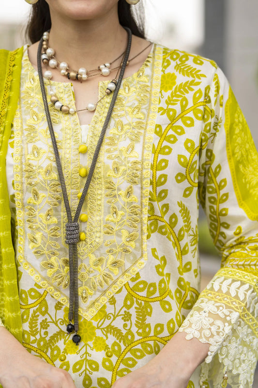 Yellow and white embroidered traditional outfit with a necklace.