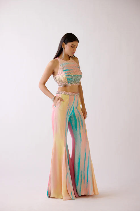 Woman wearing a colorful two-piece outfit with a white background