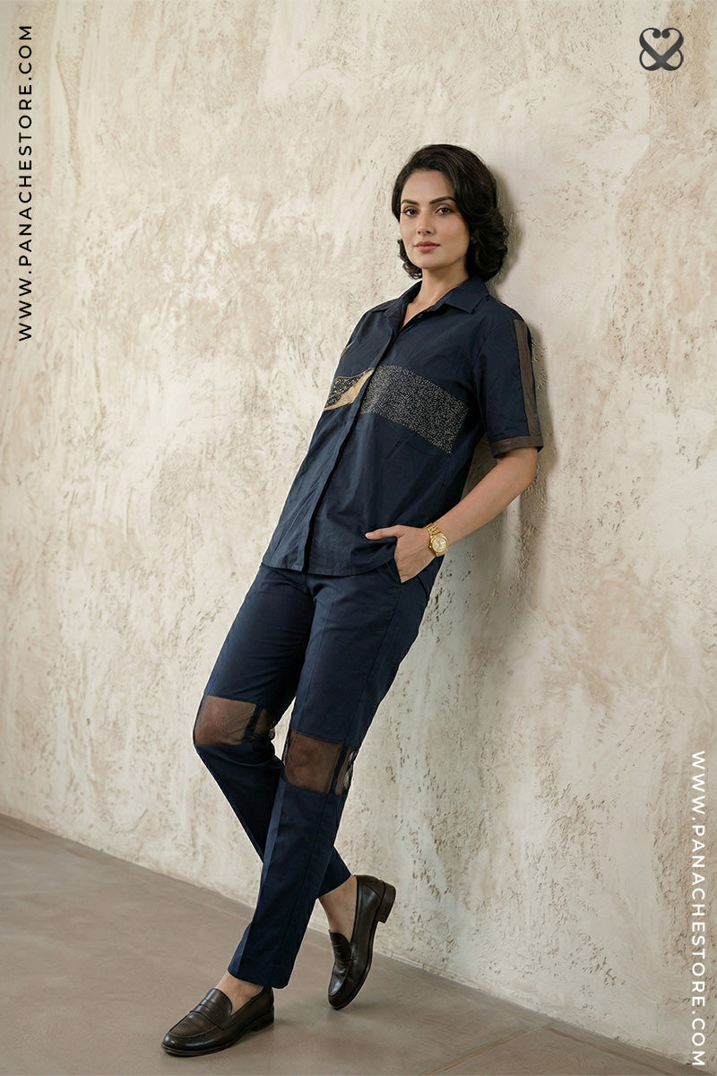 Woman wearing a navy blue outfit with a textured wall background