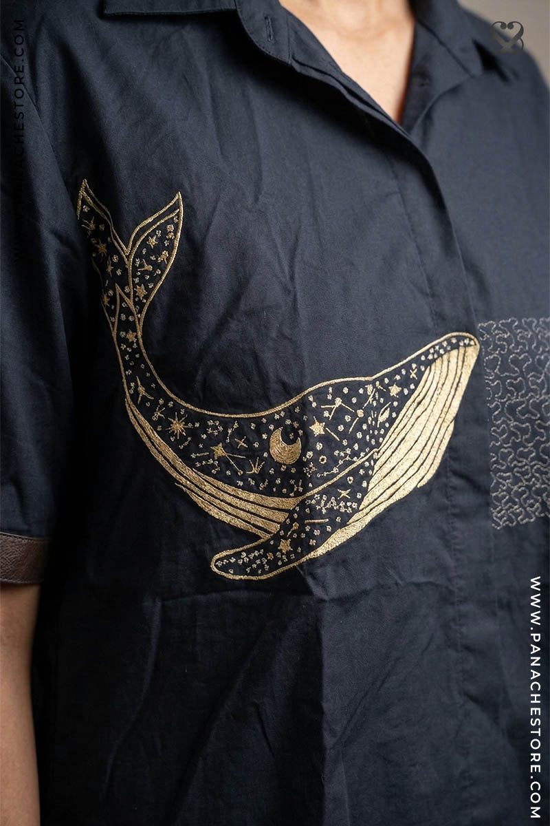 Black shirt with gold whale design on a person wearing it