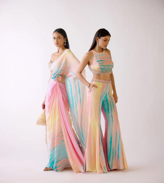 Two women wearing colorful, patterned outfits on a white background