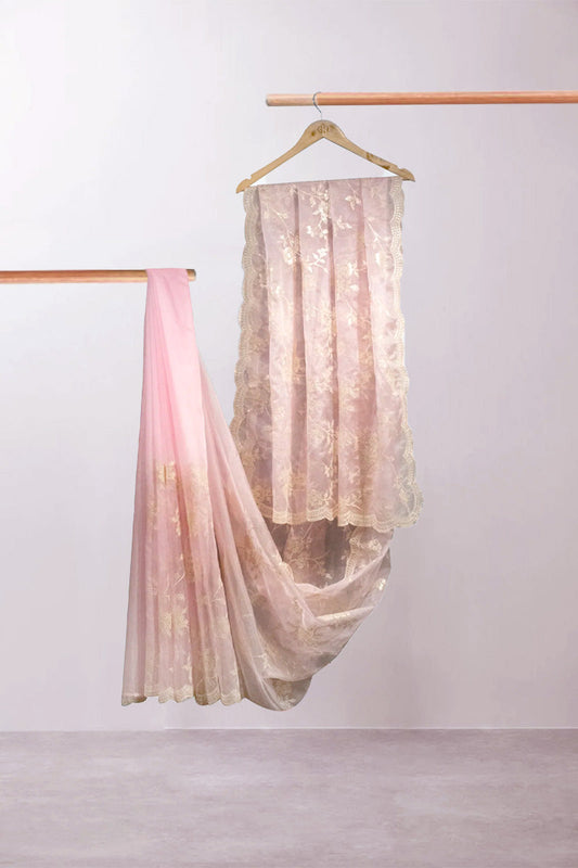 Sheer pink and gold fabric draped over a hanger against a white background